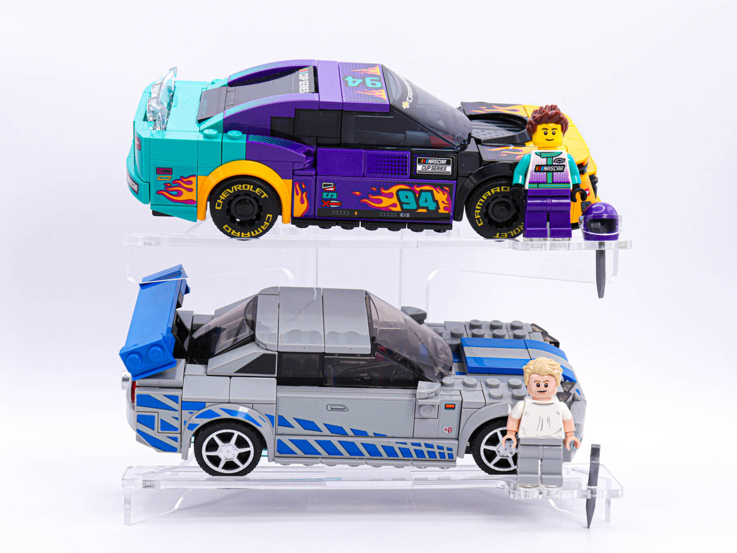 LEGO® display BRIX+ Display Stand with two LEGO® Speed Champions NASCAR® Next Gen Chevrolet Camaro ZL1 (76935), LEGO® 2 Fast 2 Furious Nissan Skyline GT-R (R34)(76917). 